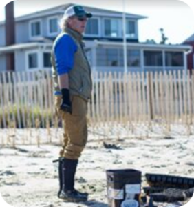 a man standing in the sand with his boots on