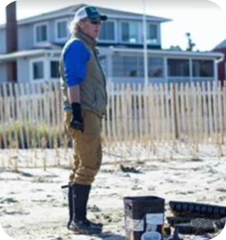 a man standing in the sand with his boots on