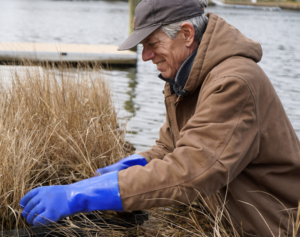 an older man in a brown jacket and blue gloves