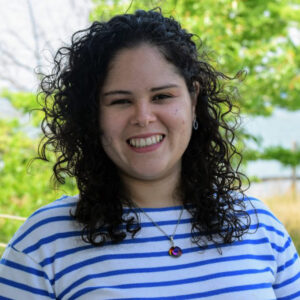 a woman with curly hair smiling at the camera