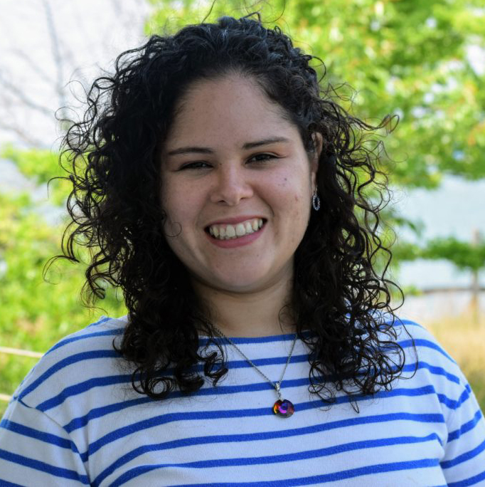 a woman with curly hair smiling at the camera
