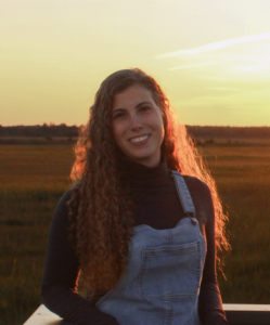 a woman standing next to a truck in a field