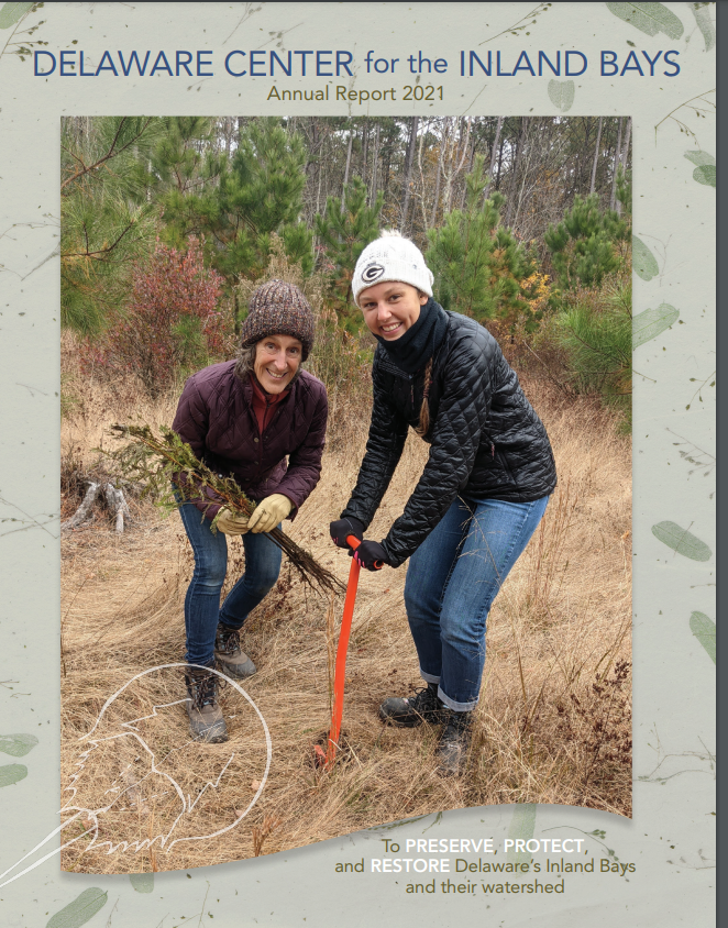 two women are holding shovels in the grass