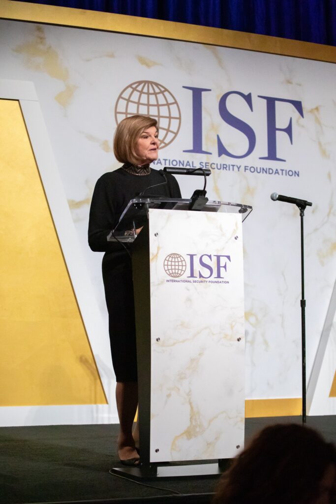 a woman standing at a podium in front of a microphone