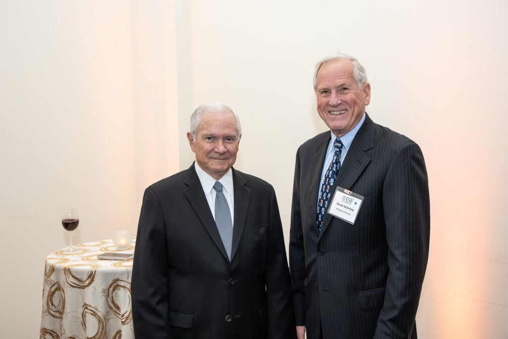 two men standing next to each other in front of a table