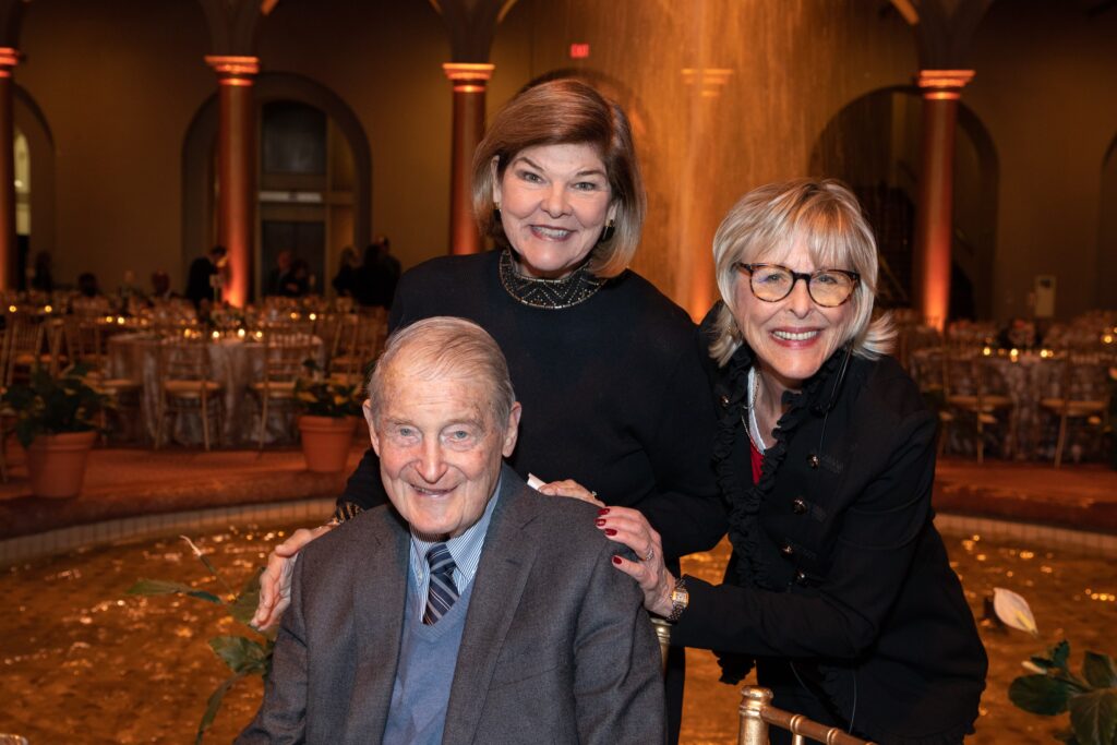 two women and an older man posing for a photo