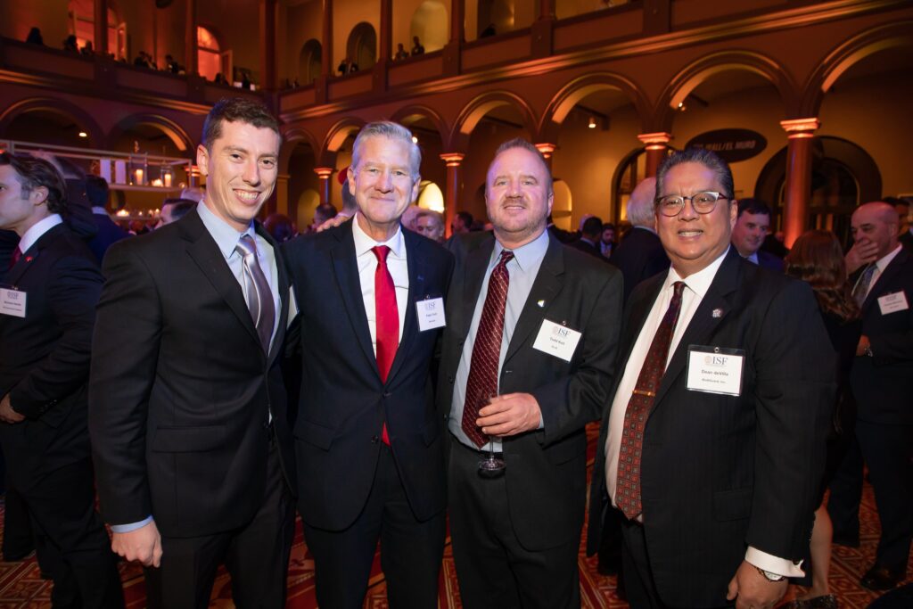 three men in suits and ties posing for the camera