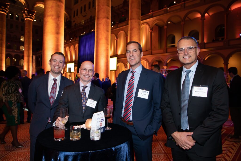 four men in suits posing for a photo