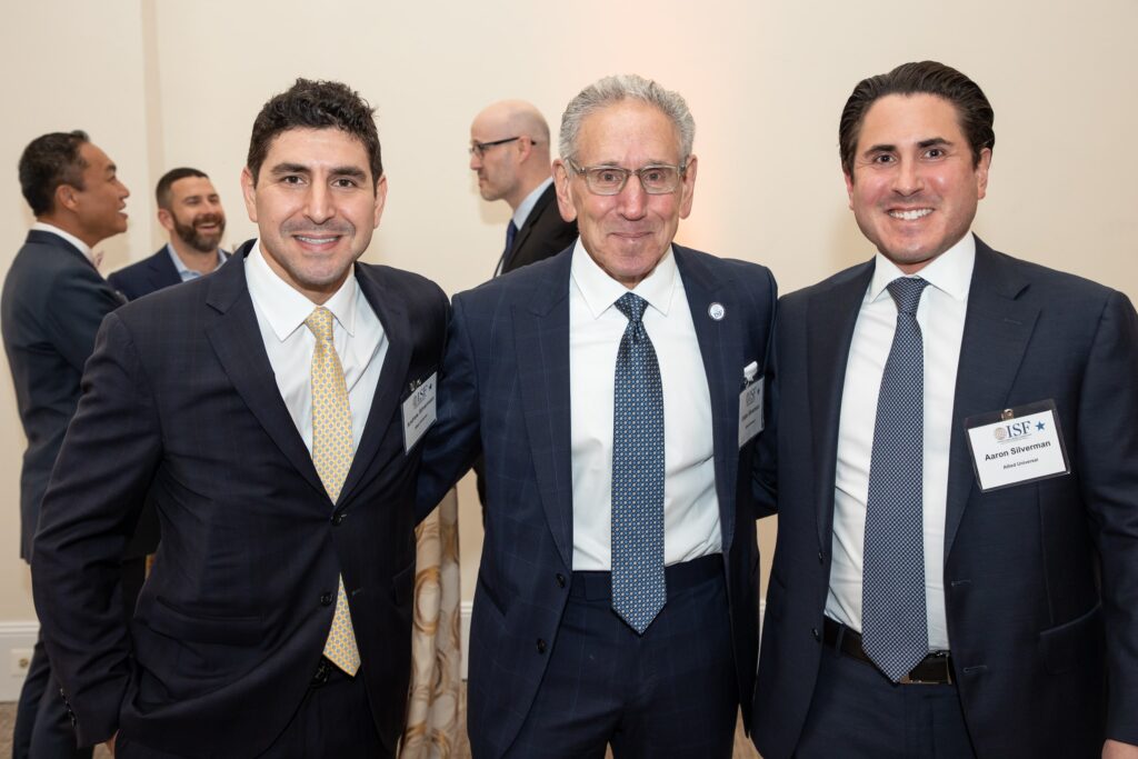three men in suits and ties posing for the camera