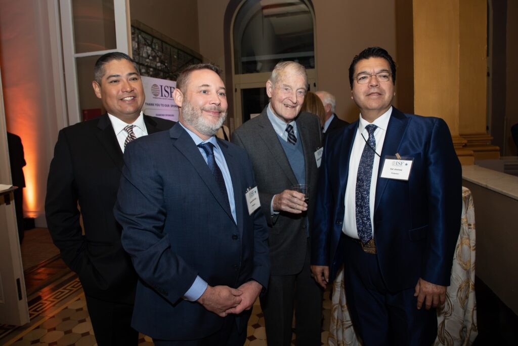 four men in suits and ties posing for the camera