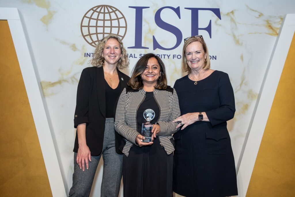 three women standing next to each other holding an award