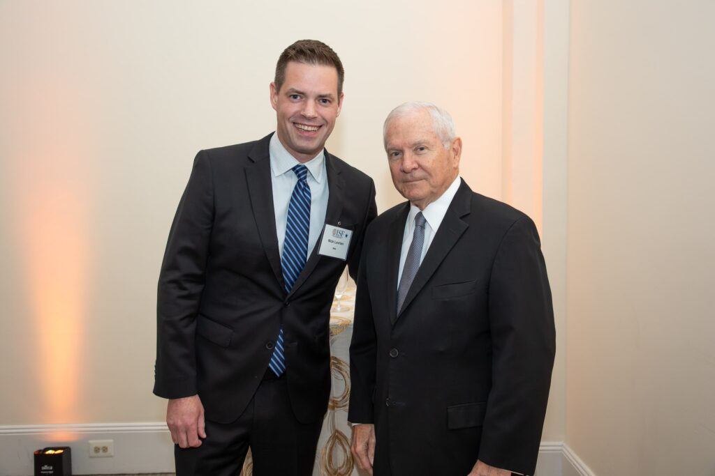 two men standing next to each other in suits