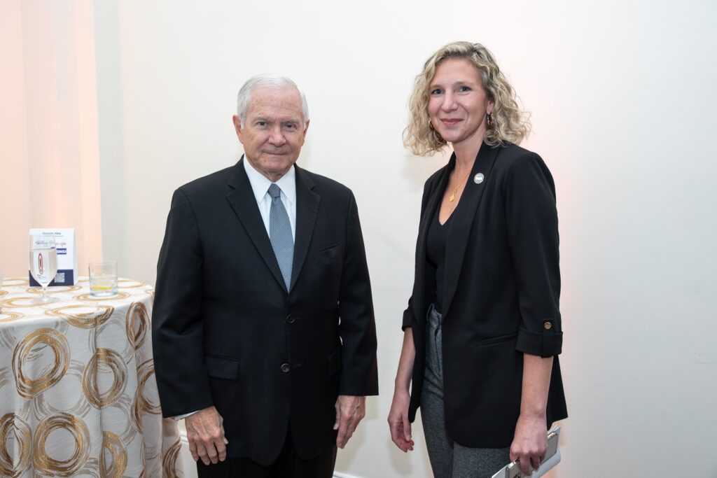 two people standing next to each other near a table