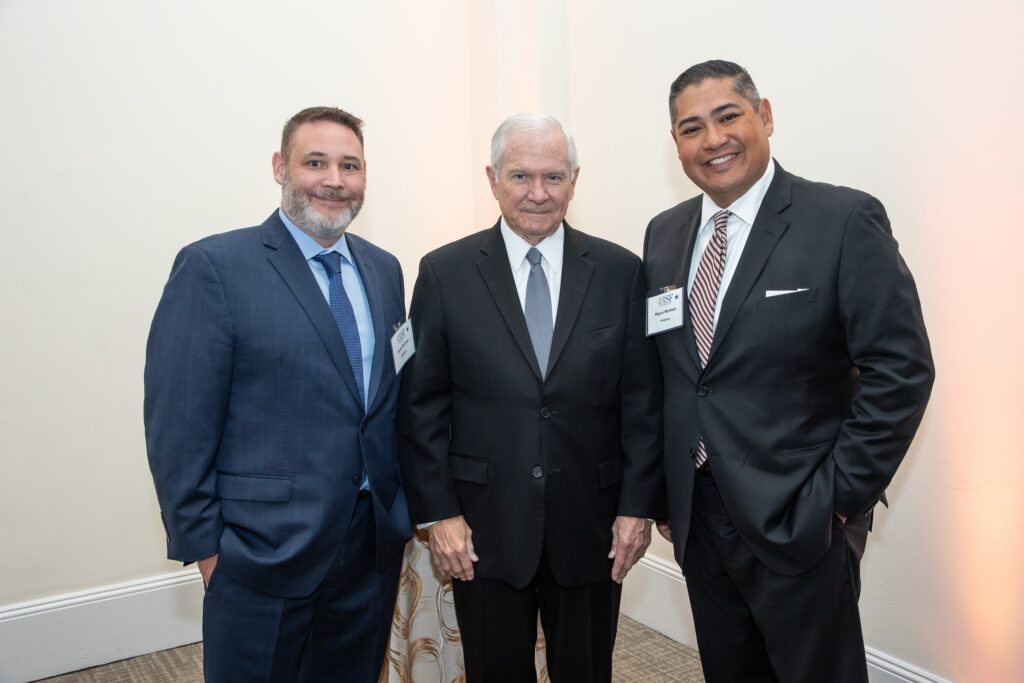 three men standing next to each other in suits