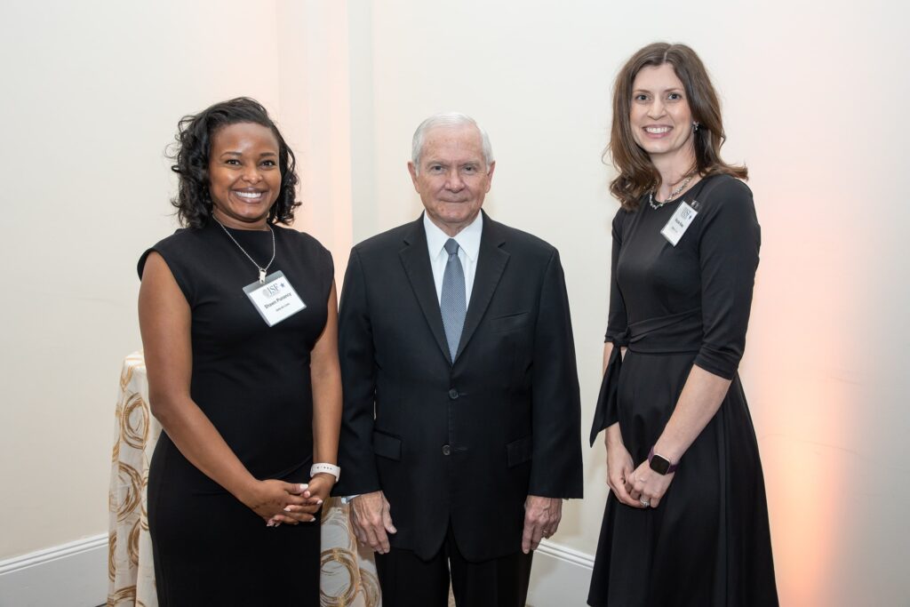three people standing next to each other in front of a wall