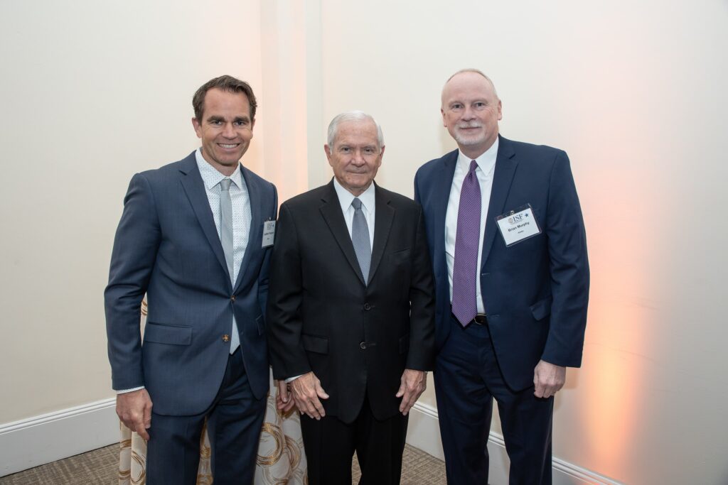 three men standing next to each other in suits