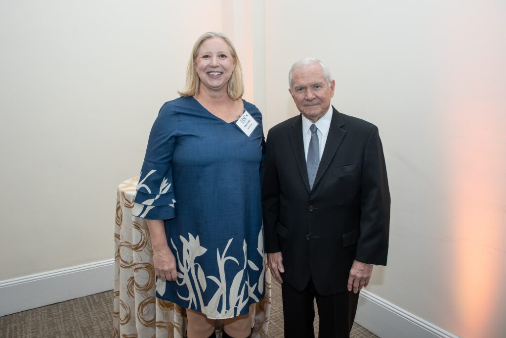 two people standing next to each other in a room