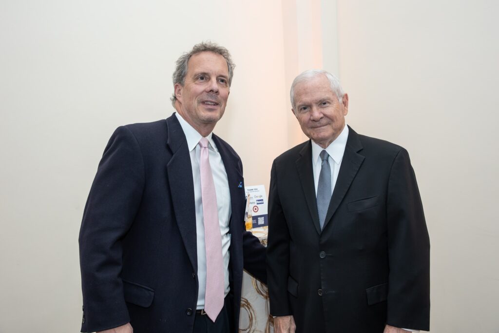 two men standing next to each other in suits