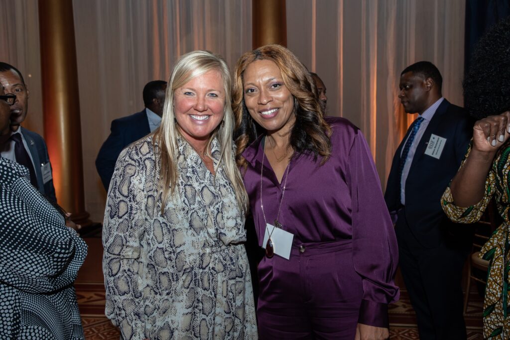 two women standing next to each other smiling