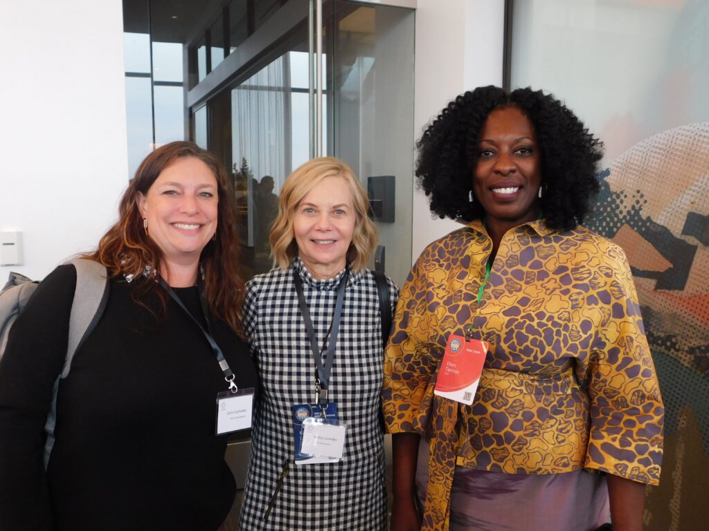 three women standing next to each other smiling