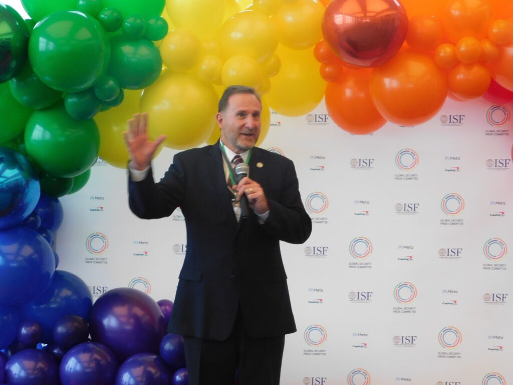 a man standing in front of a rainbow colored wall