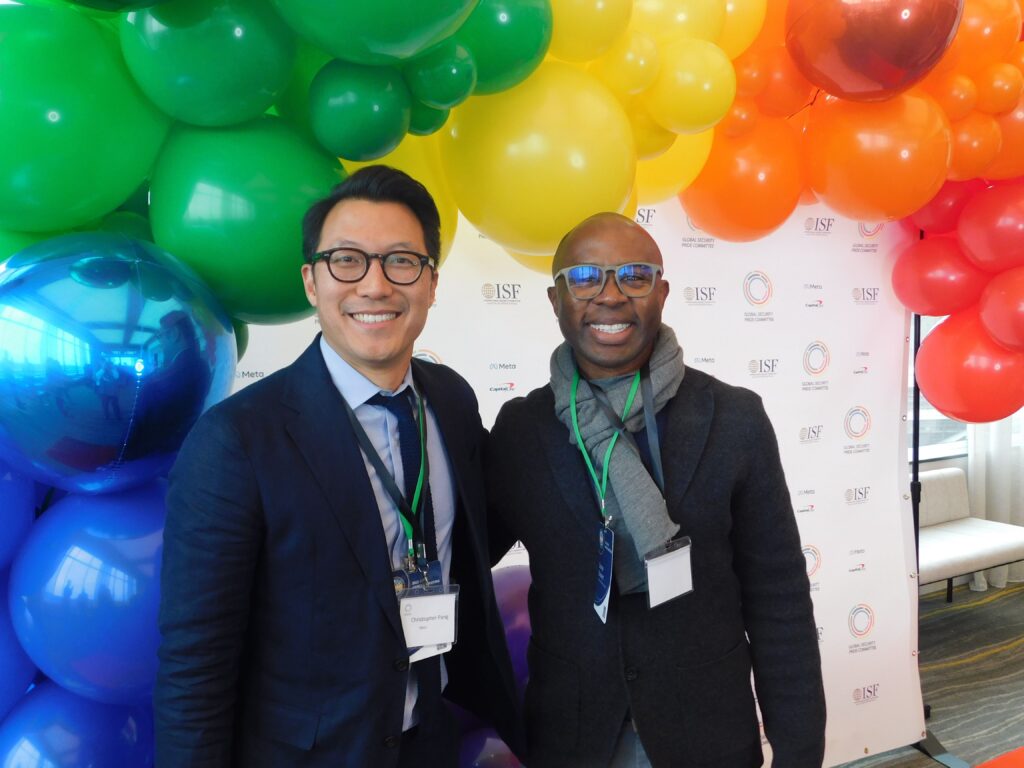 two men standing next to each other in front of balloons