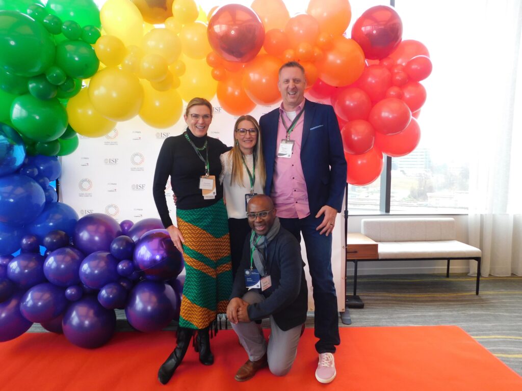 a group of people standing next to each other in front of balloons