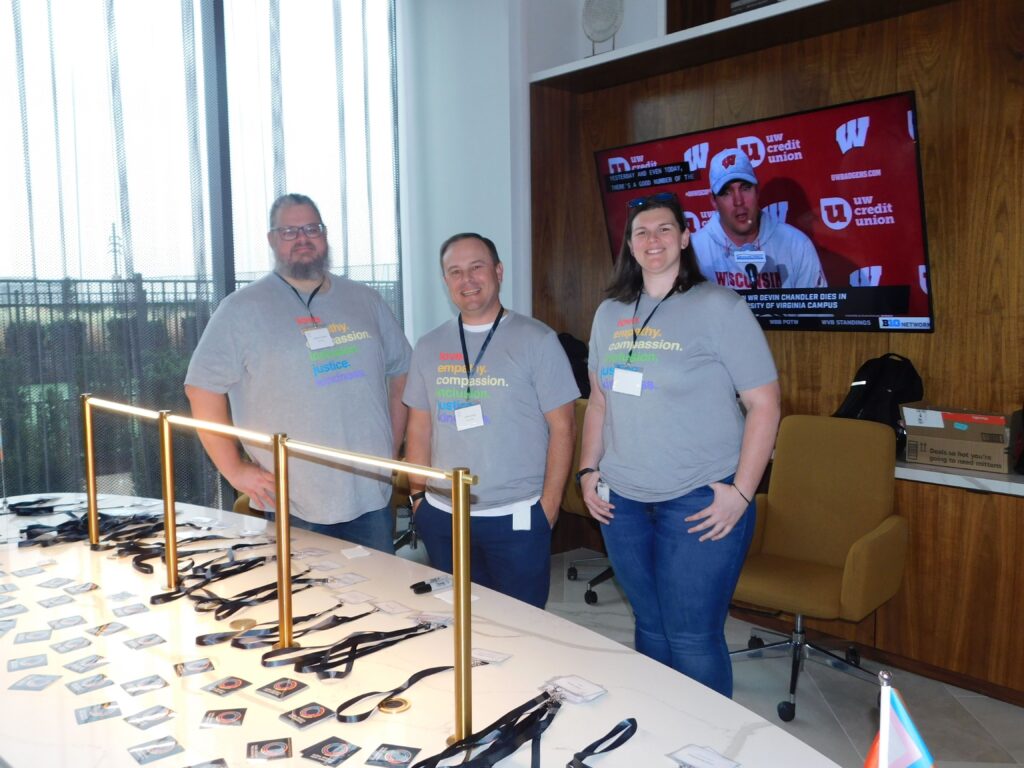 three people standing in front of a table with glasses on it