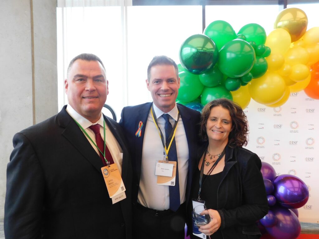 three people standing next to each other in front of balloons