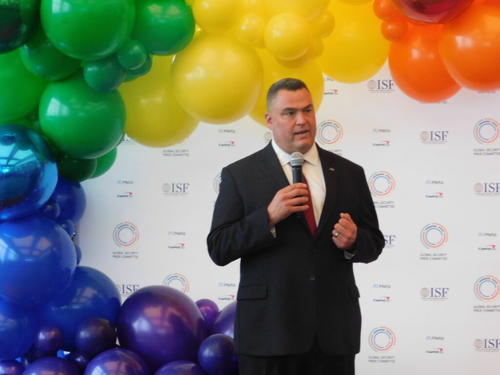 a man standing in front of balloons holding a microphone