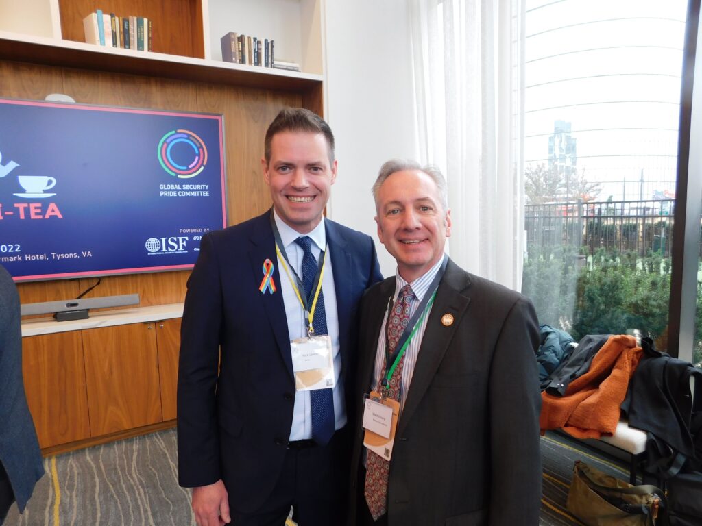 two men standing next to each other in front of a tv
