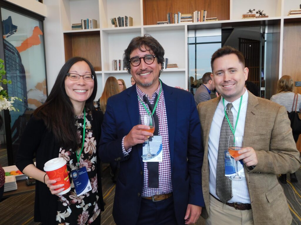 two men and a woman are holding drinks