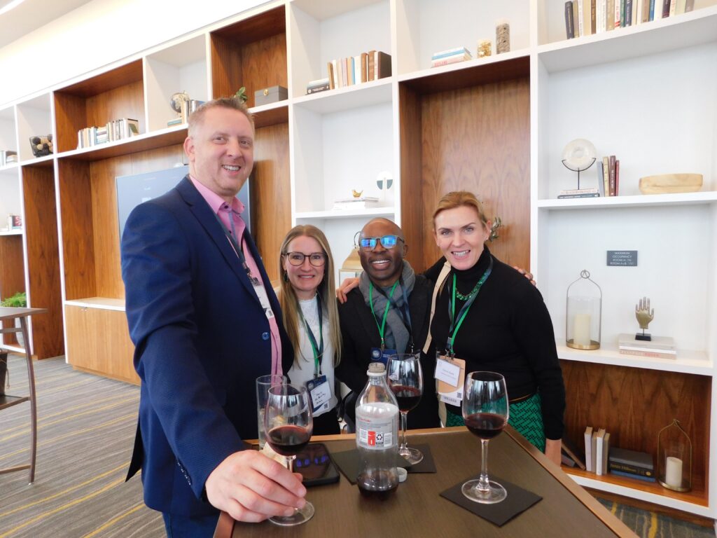 a group of people standing around a table with wine glasses