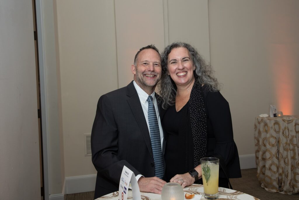 a man and woman standing next to each other at a table