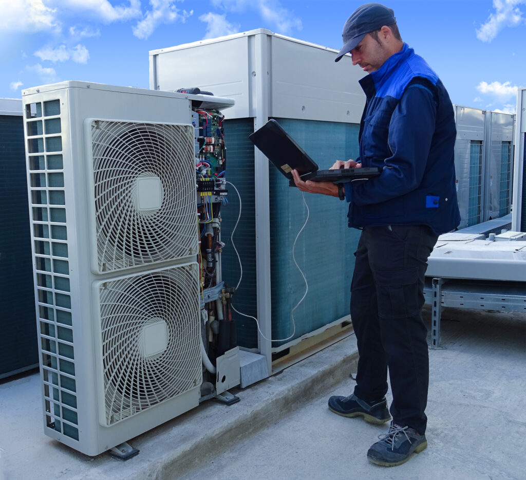 a man standing in front of two air conditioners