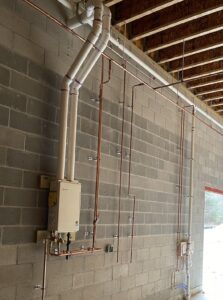 a room with pipes and a wall mounted heater