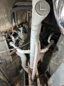 a large pipe in a room with pipes and wires