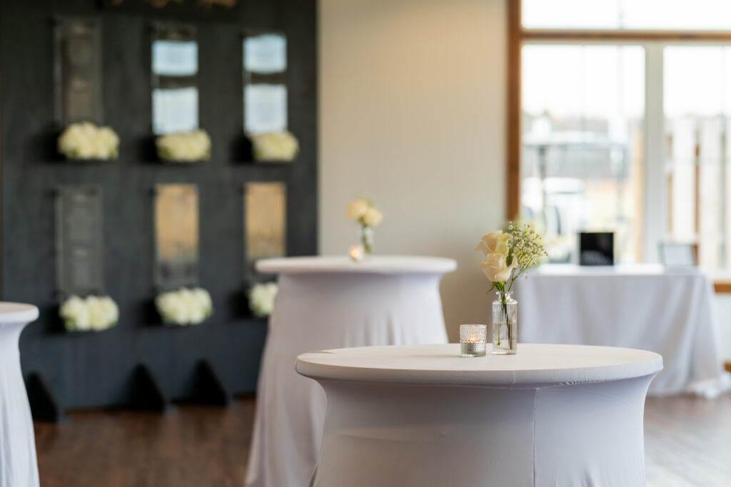 Bud Vases and a candle sitting on covered cocktail barrels in the sunporch at King Cole Farm.