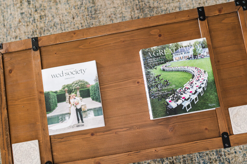 Image including the wooden coffee table and wedding/party related books in The Residence at King Cole Farm.