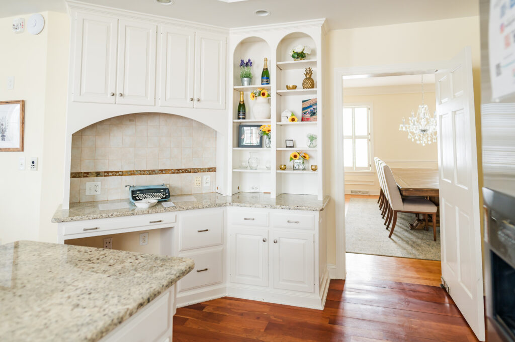 Image including the kitchen countertops, typewriter book, decorative shelves, and entrance to the formal dining room in the Residence at King Cole Farm.