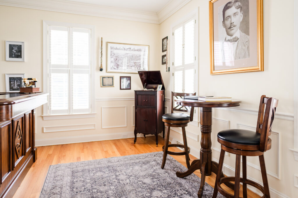 Image including wall art, instruments, old record player, and a high top table with chairs in the Prohibition Bar in The Residence at King Cole Farm.