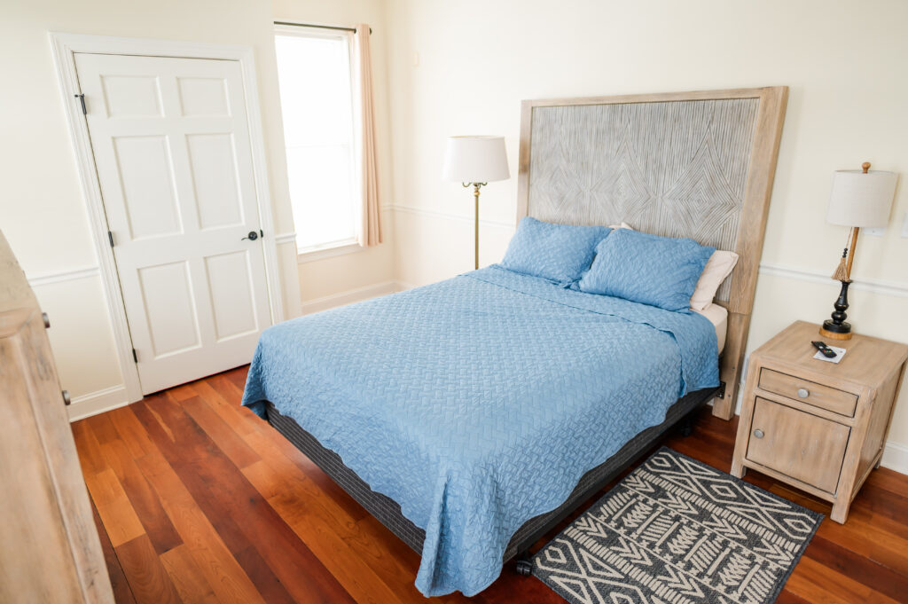 Image featuring queen size bed, rung, lamp, closet, and window in the ADA Bedroom at The Retreat at King Cole Farm.