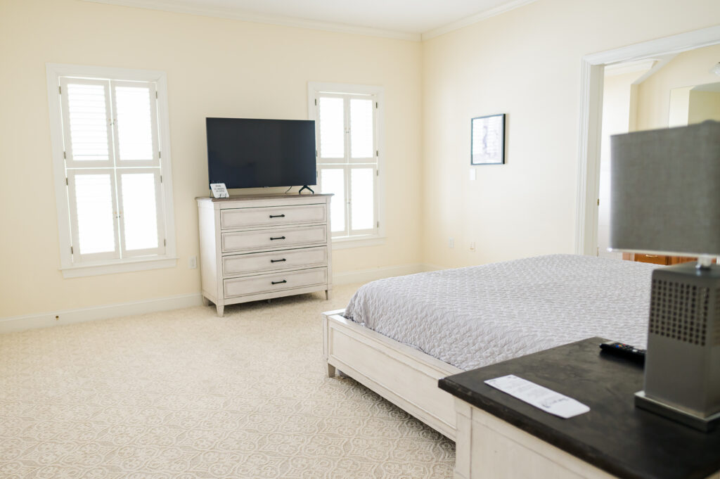 Image featuring the king bed, dresser with TV, side table, and wall art in the Sunset Bedroom in the Retreat at King Cole Farm.
