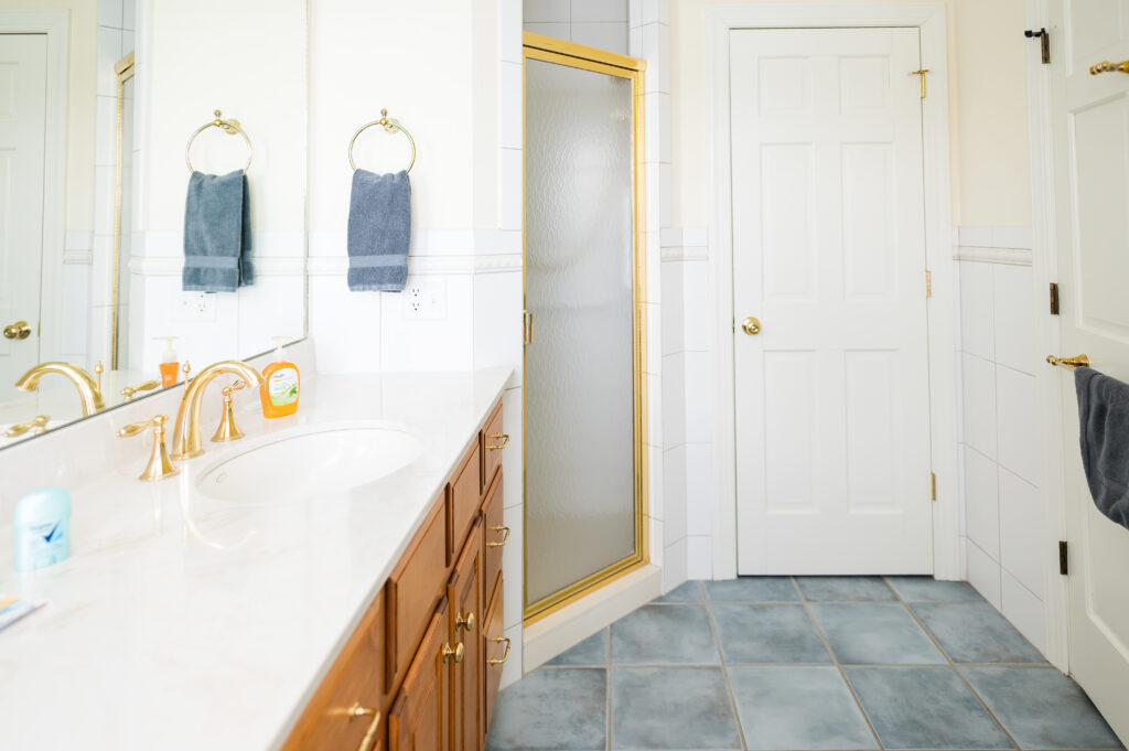 Image featuring the shower entrance, sink vanity, mirror, and hand towel in the Sunset Bathroom in the Retreat at King Cole Farm.