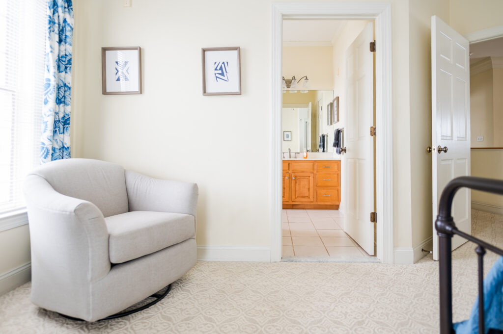 Image of a swivel chair, art, and the entrance to the en-suite bathroom in the Bayview Room at King Cole Farm.