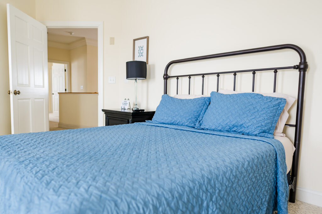 Image of a bed, side table, and lamp in the Bayview Room at King Cole Farm.