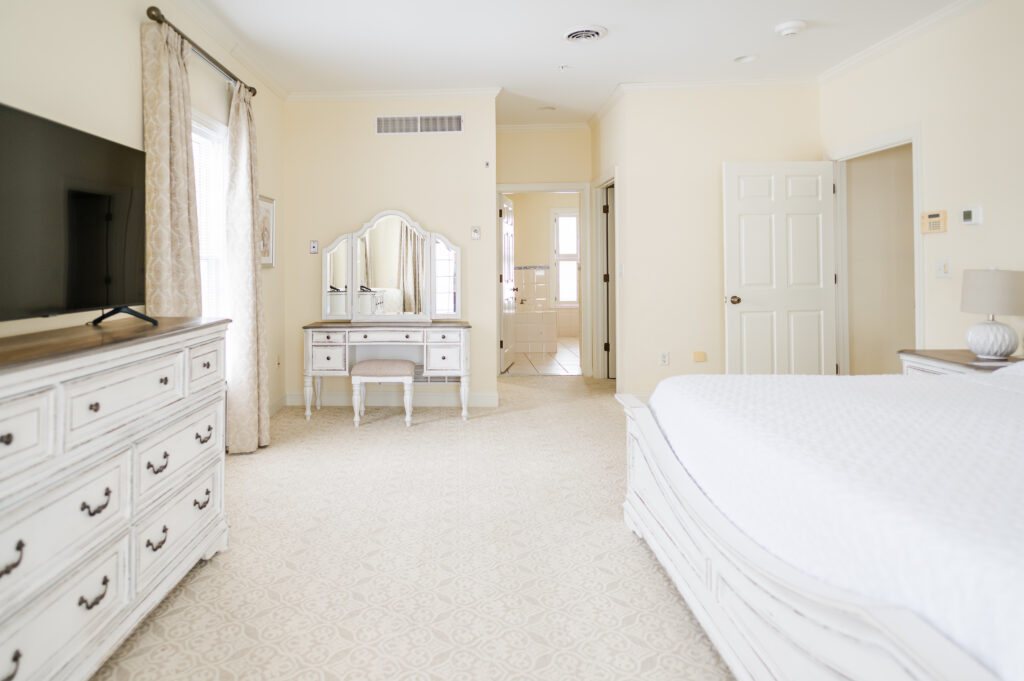 Image of the dresser, vanity, and bed in the bridal suite bedroom at King Cole Farm