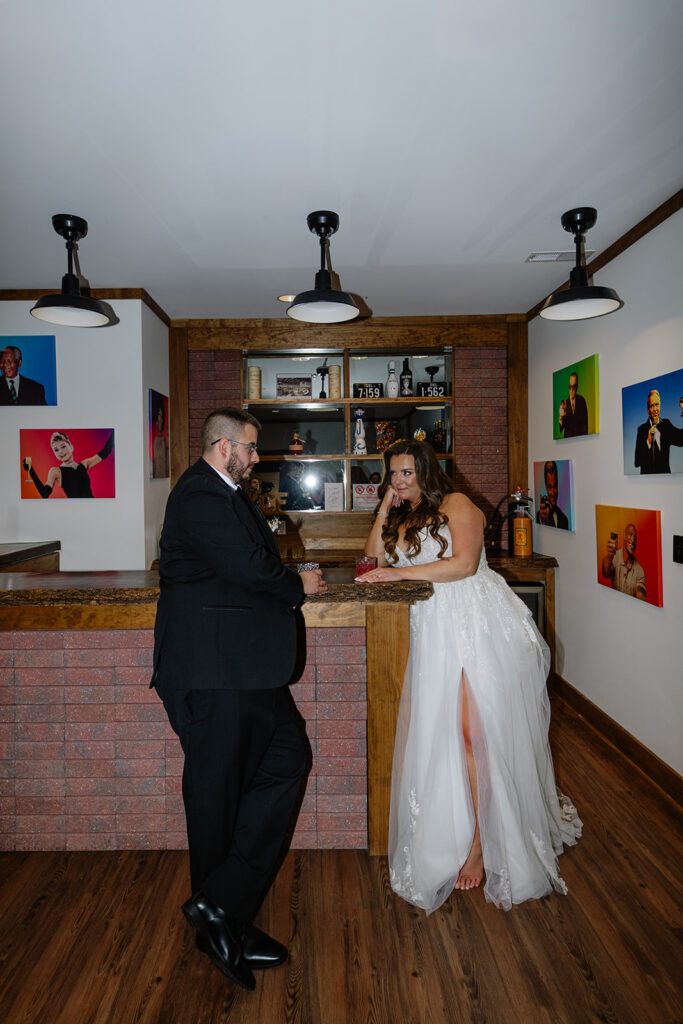 Bride and Groom sharing drinks at the bar in the Groomsmen's Lodge at King Cole Farm