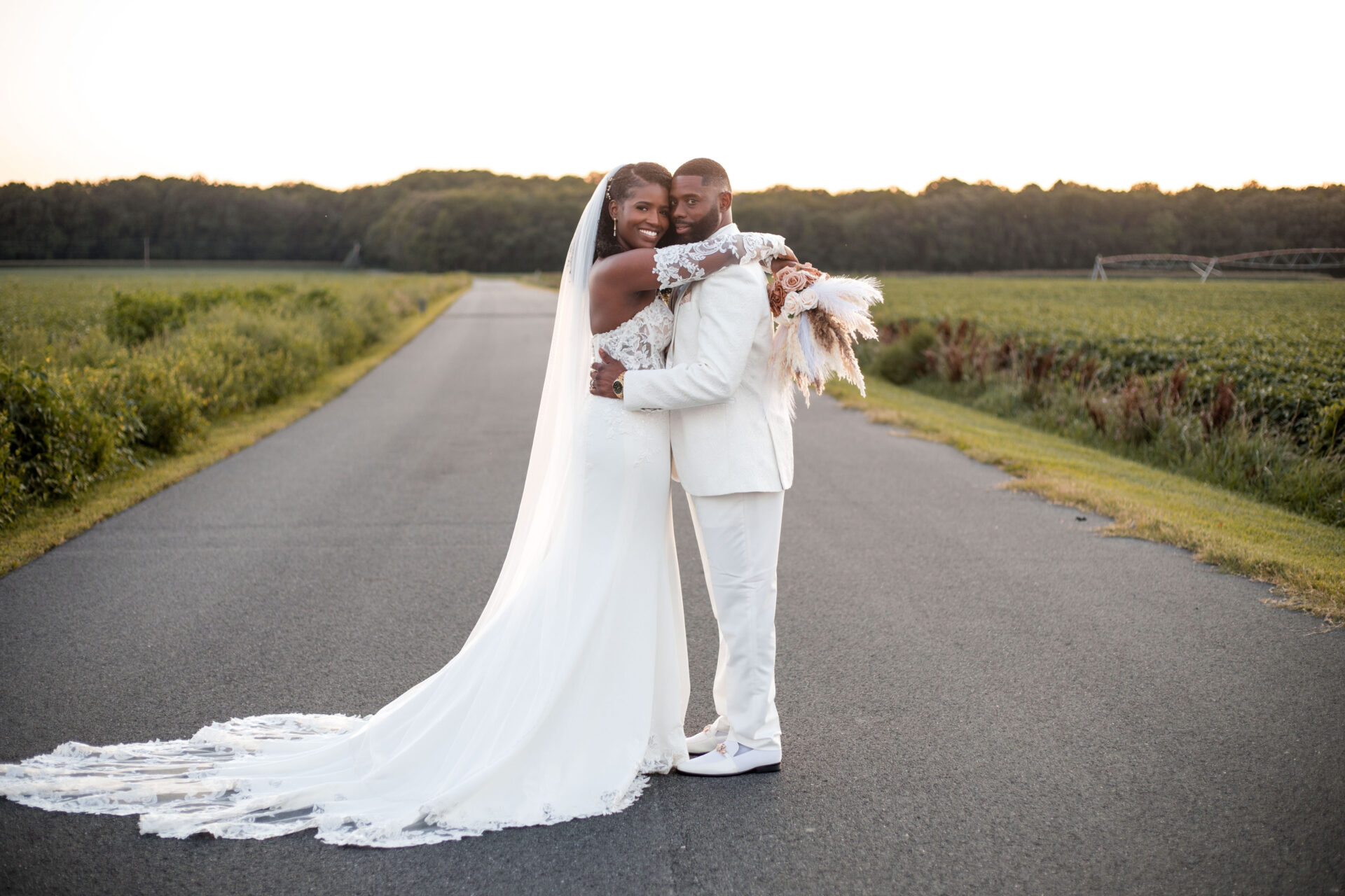 Bride and Groom on the driveway surrounded by corn fields at King Cole Farm