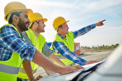 three men in safety vests pointing at something